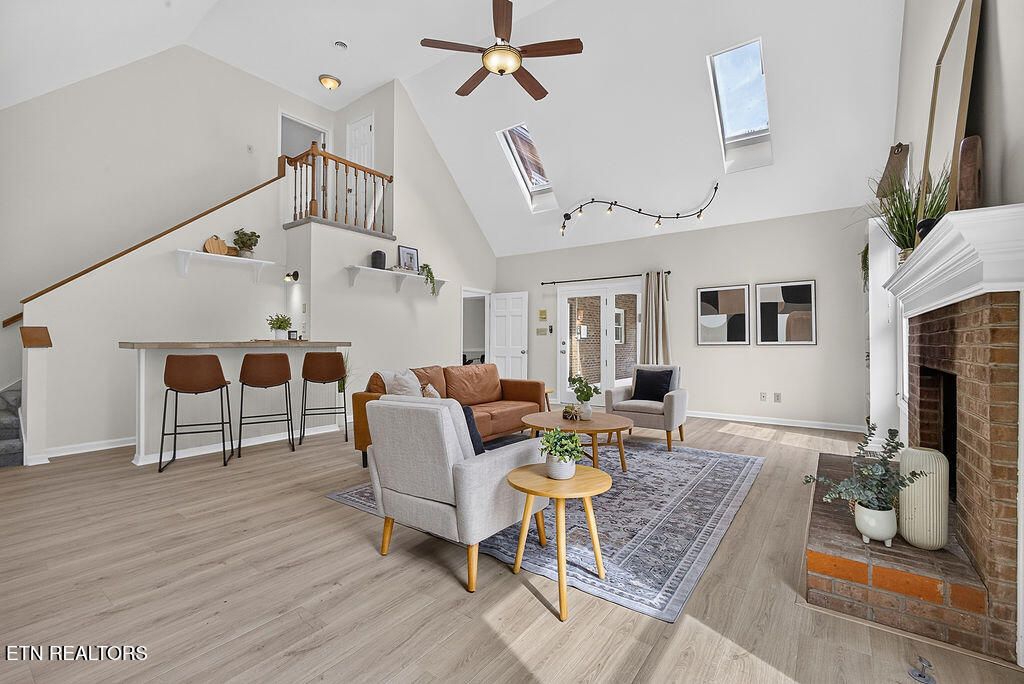Two-story den with a cathedral ceiling, skylights and a brick gas log fireplace inside 12736 Broken Saddle Rd, Knoxville, TN