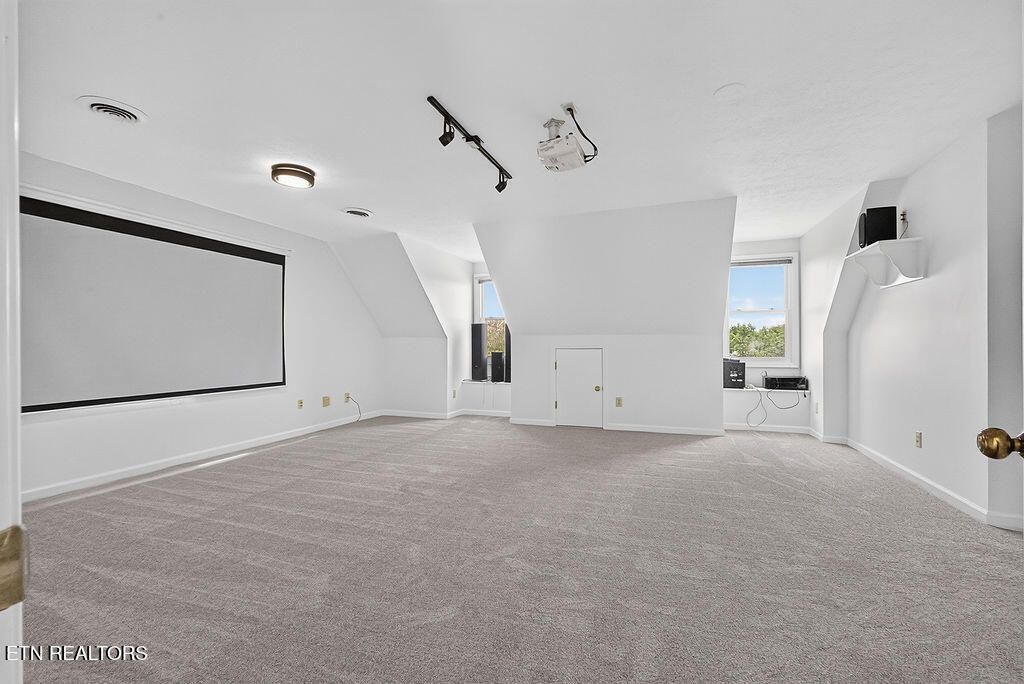 Upstairs movie room with a projector screen and carpet at 12736 Broken Saddle Rd, Knoxville, TN 37934