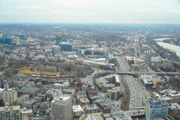 Elevated view of city blocks, a baseball stadium and major roads.