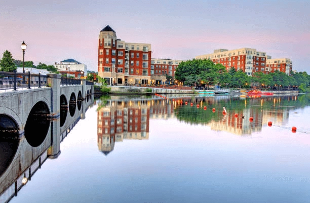 Arched bridge and brick buildings reflected in calm water