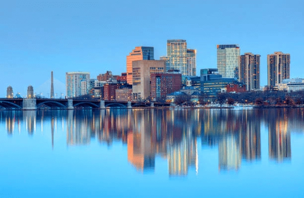 Urban skyline and bridge reflected in still river water