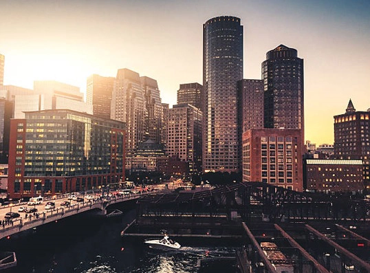 Waterfront buildings and marina at sunset.