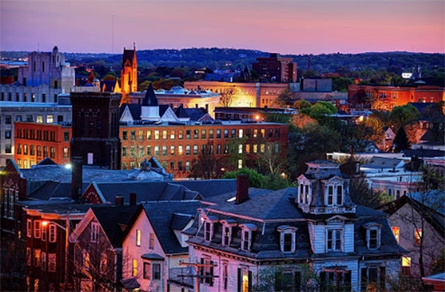 Older city buildings and church spires at dusk.