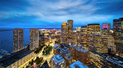 Illuminated waterfront skyline at dusk.