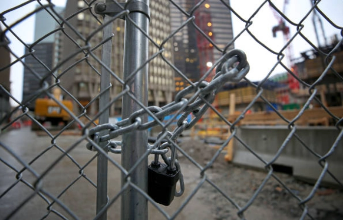 Padlocked chain-link gate at a construction site.