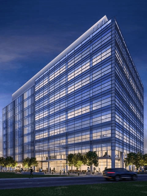 Nighttime rendering of a glazed building beside trees and a street.