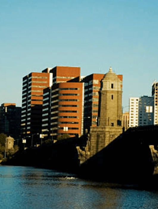 Riverfront buildings and a stone bridge structure.