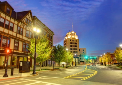 Evening city street with a clock tower and illuminated buildings