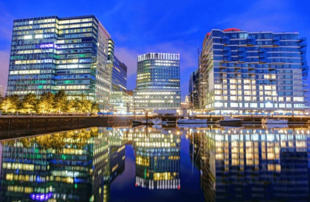 Illuminated waterfront buildings reflected in the water at dusk
