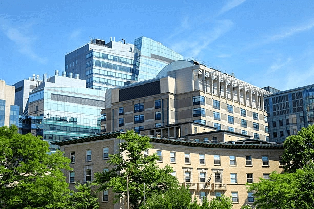 Multi-story buildings and trees under a blue sky