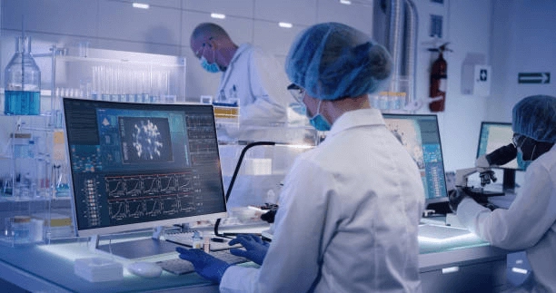 Researchers using computer displays and laboratory equipment