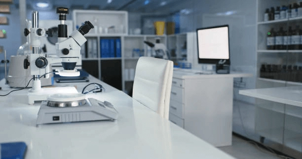 Microscope and other laboratory equipment beside windows