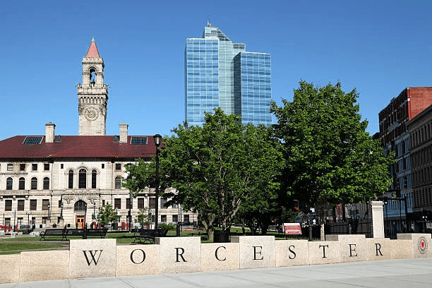 Civic building and tower behind a stone Worcester sign