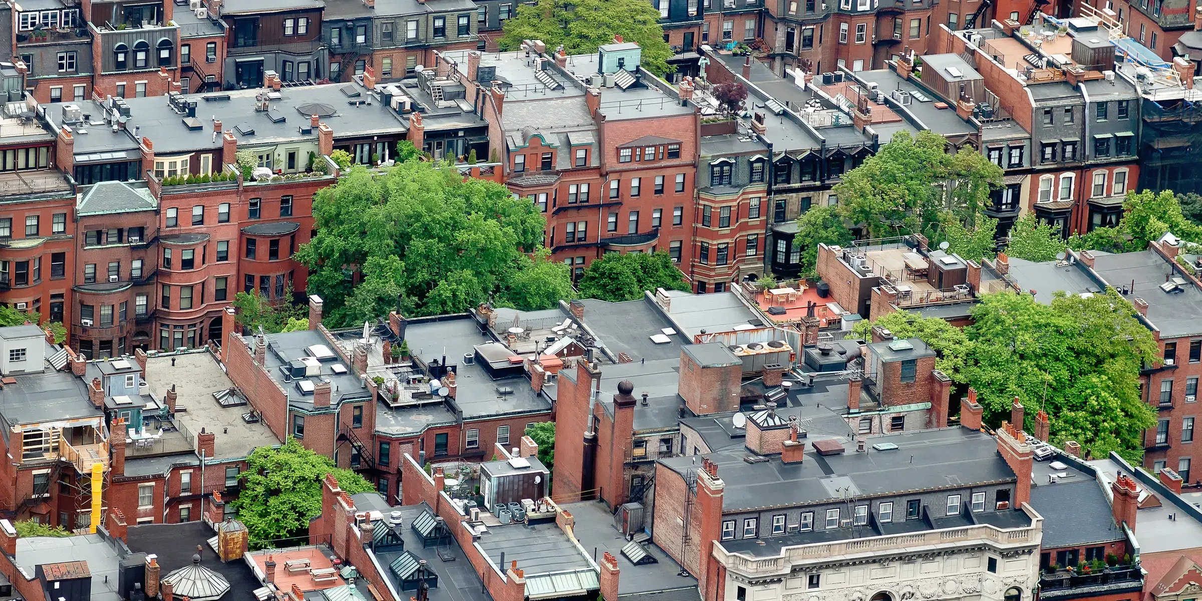 Boston brick row houses, rooftops and leafy streets viewed from above