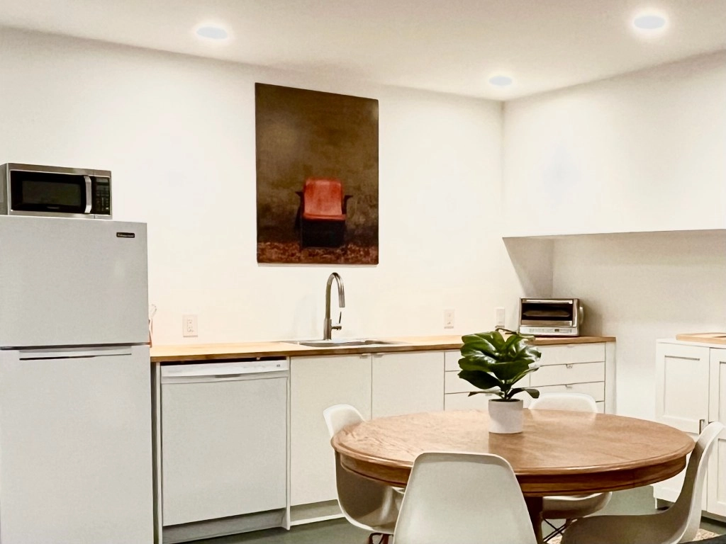 Unit Three — The Garden-Level Retreat Modern kitchenette with butcher block countertop and stainless appliances.
