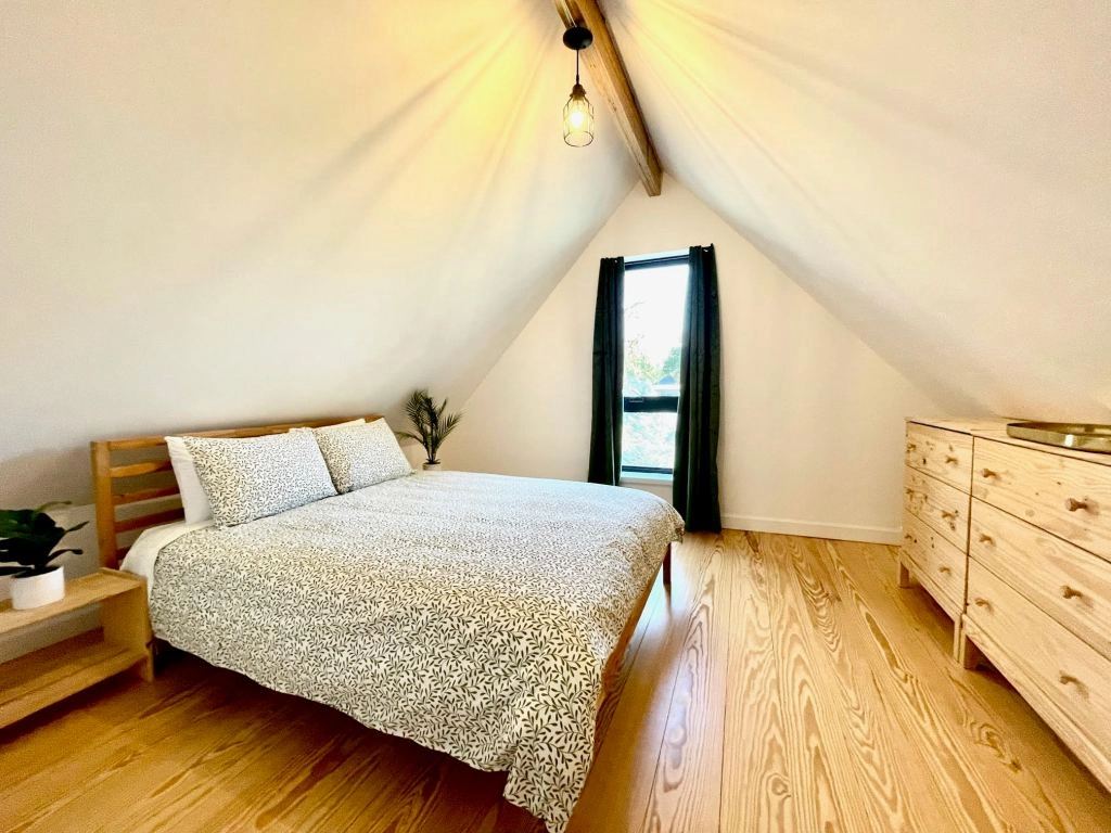 East-facing bedroom with vaulted ceiling and boutique-style wardrobe racks.