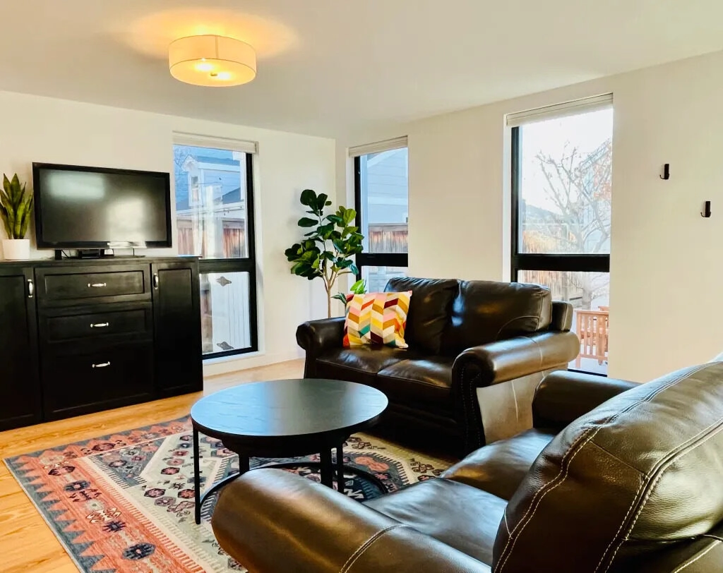 The Denver Longhouse Step-free living room in Unit One — wide hallways and natural light from three sides.