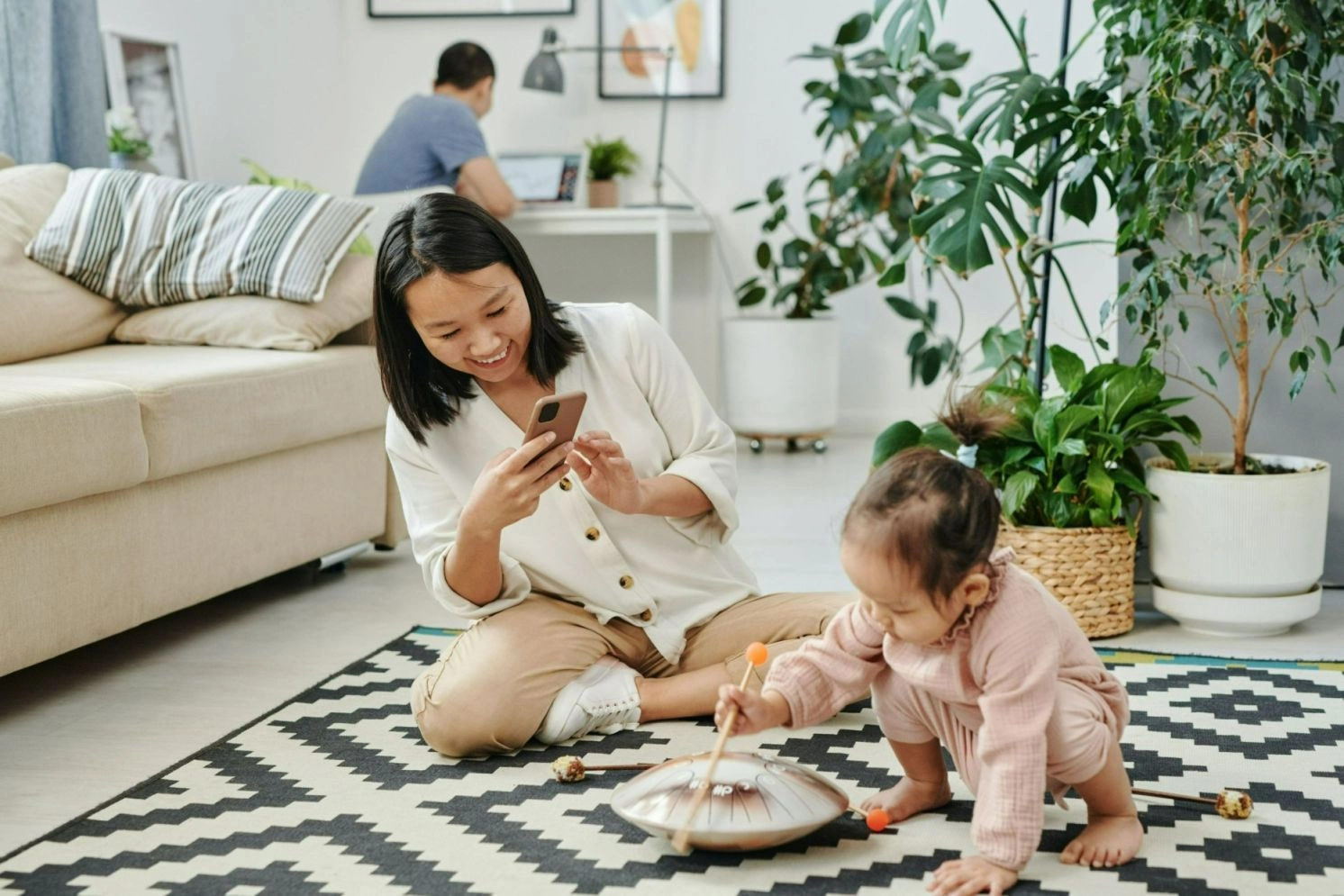 A woman taking picture of her daughter playing.