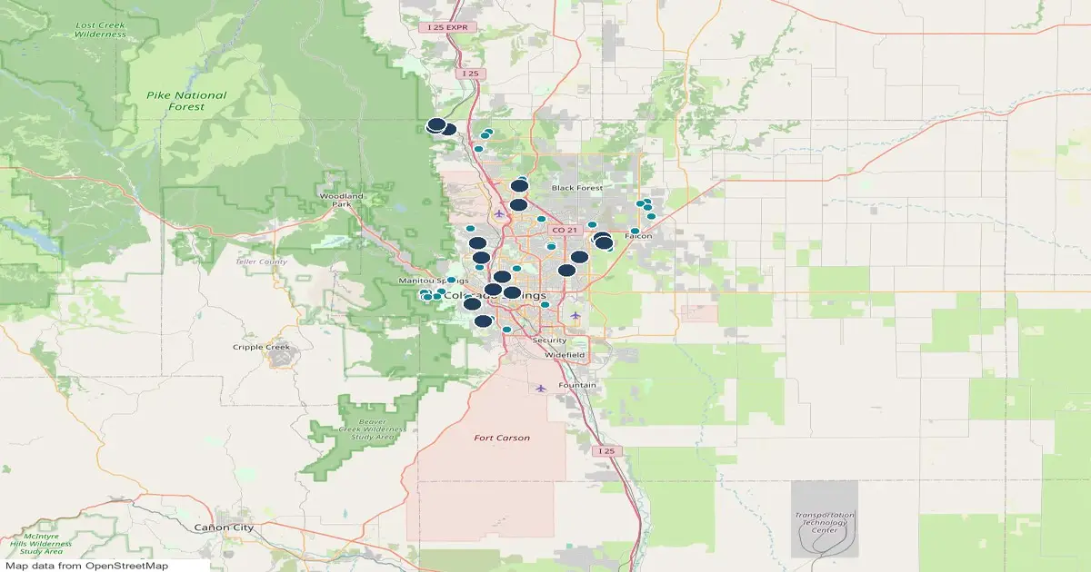Map of the Colorado Springs area showing 16 public pickleball court locations as numbered pins and 52 homes for sale near them as teal dots