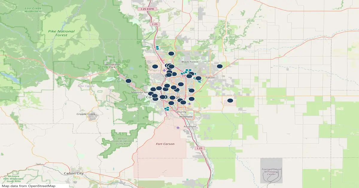 Map of the Colorado Springs area, Colorado, showing 40 dog parks as pins and 55 homes for sale whose listings name a dog park as teal dots