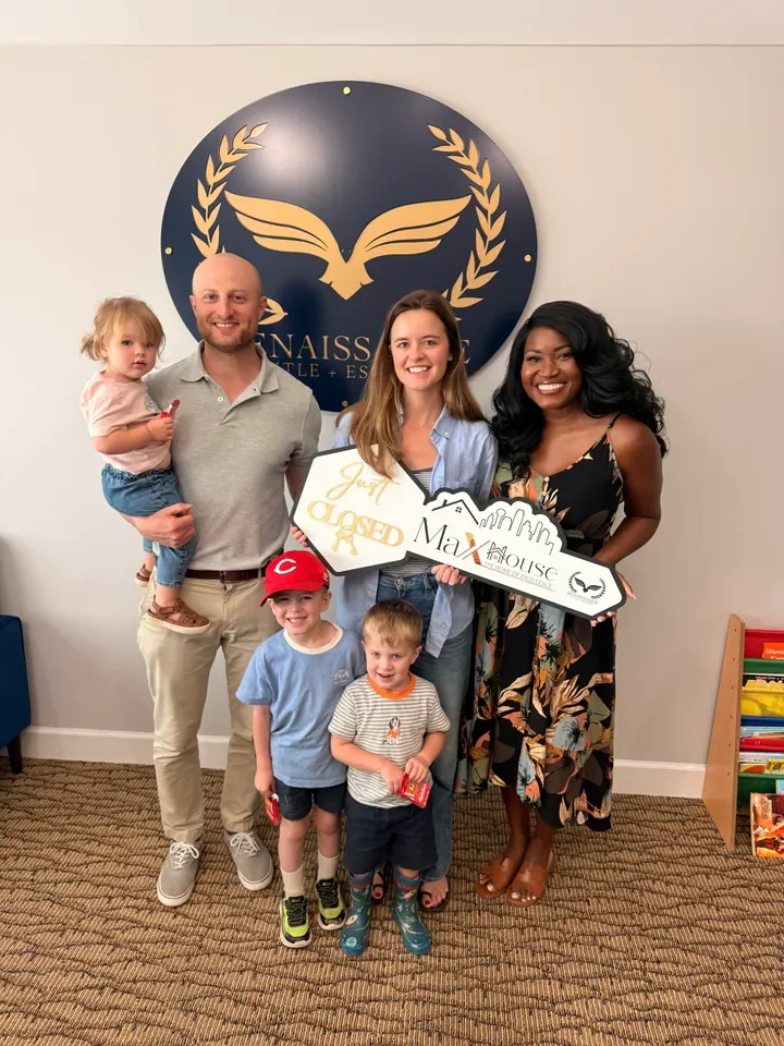 A family celebrating closing day with Britany and a MaX House key sign.