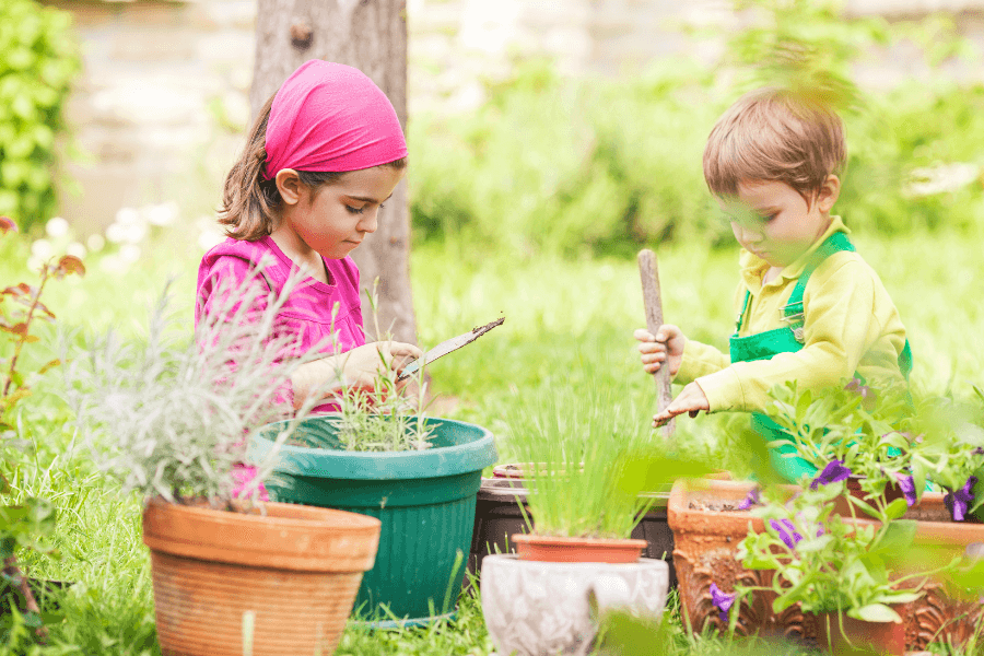 Children actively working in the garden with different tools