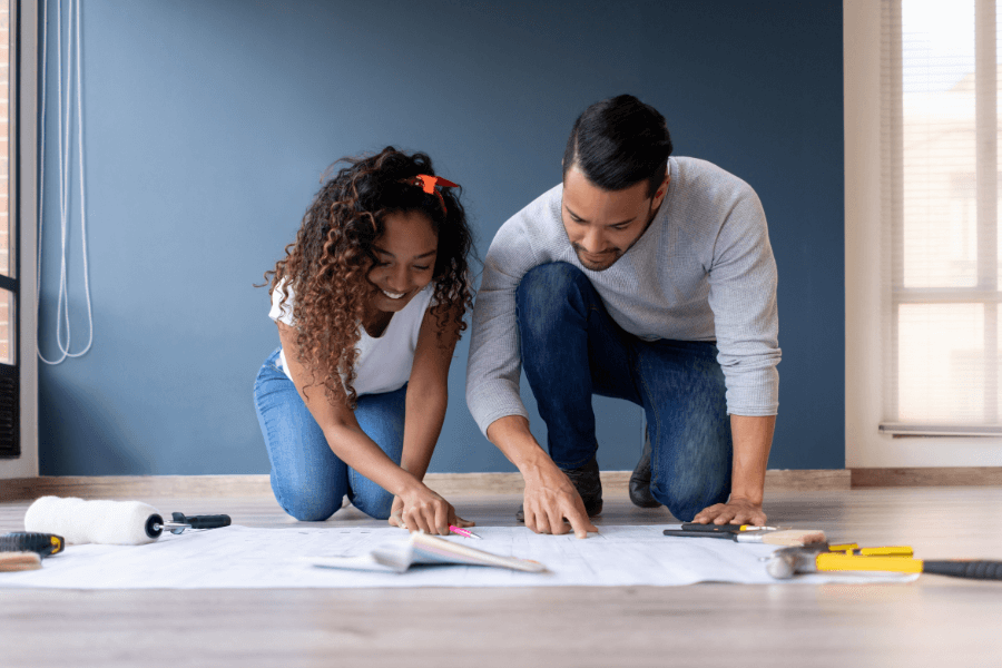 Happy couple working on plans for redecorating a room