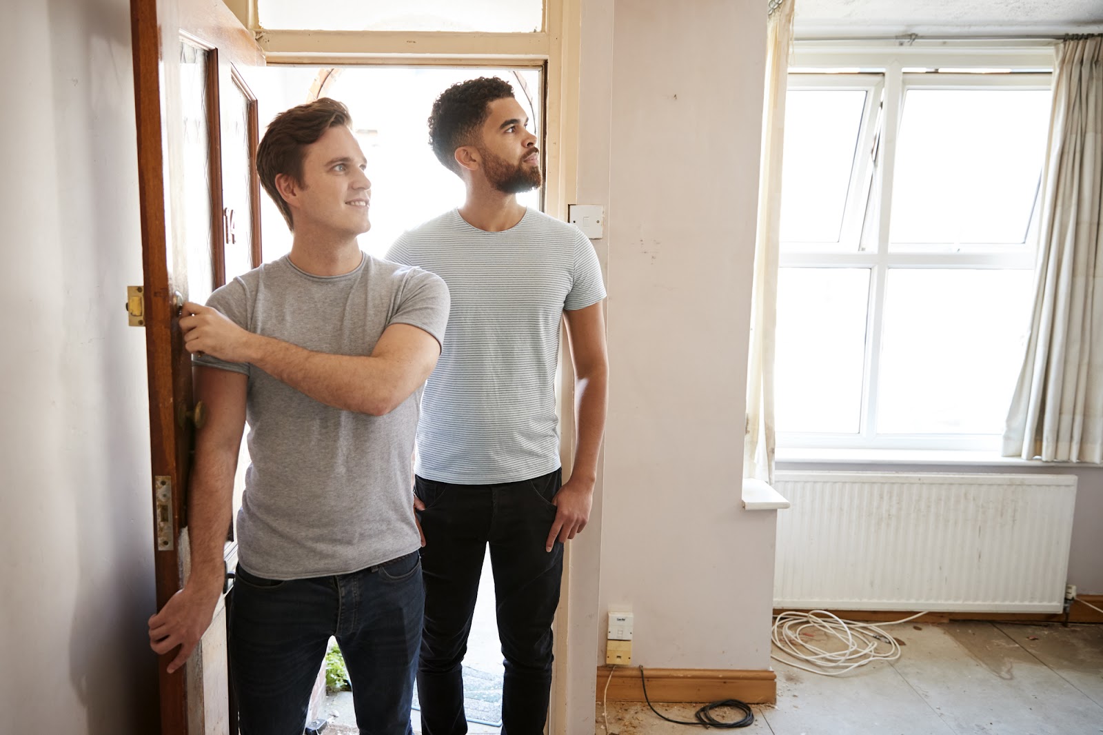 A young couple walking through the front door of a home they are touring.