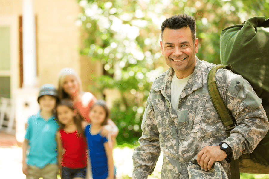 A Military family standing in front of their new home