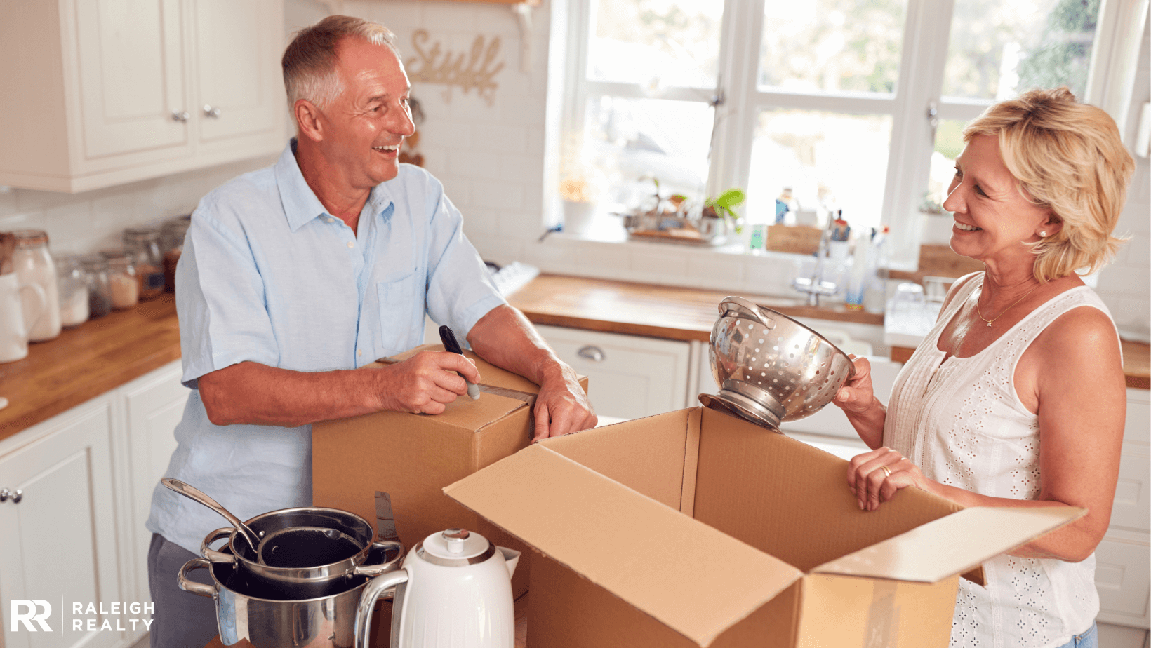 Adult seniors organizing kitchen in an effort to downsize their home one room at a time with boxes