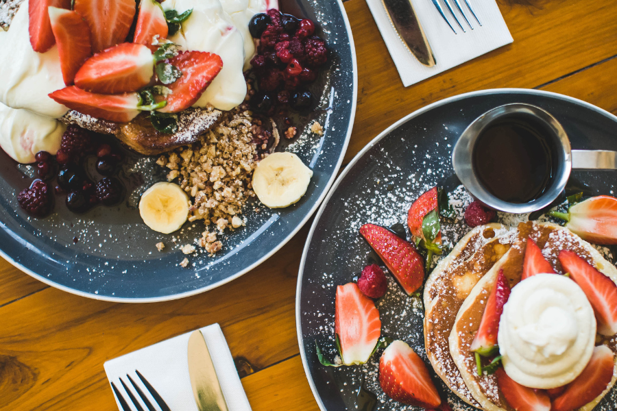 Pancakes and fresh fruit on a blue pate 