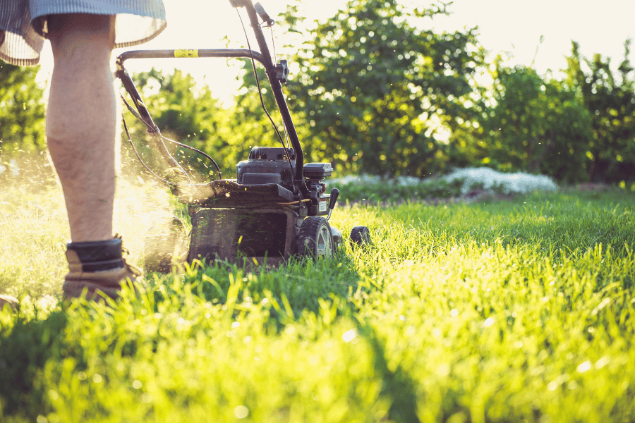 Homeowner mowing the lawn and taking care of flower beds
