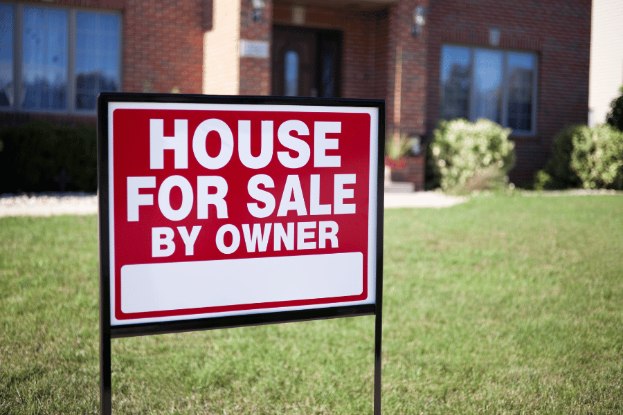 Home for sale by owner sign in front of a house 