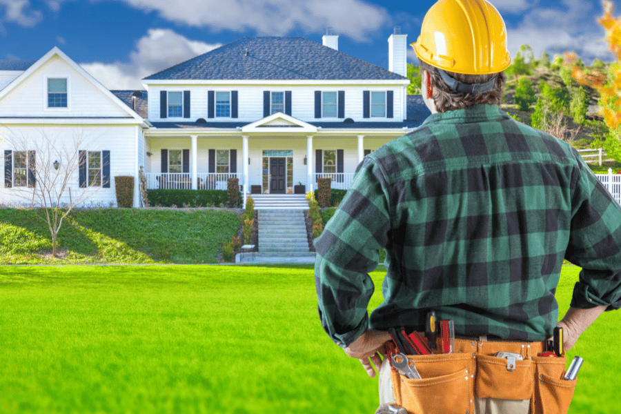 Builder with a custom built home in the background
