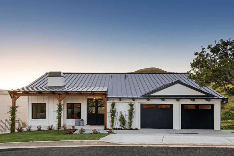 Front of modern house with two garage doors and white siding