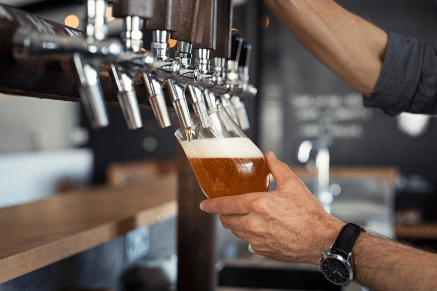 Pouring beer into glass at a brewery 