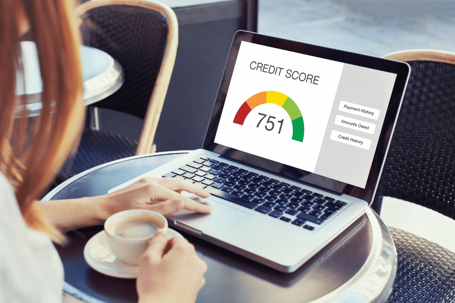 Woman checking her credit score online while drinking a cup of coffee