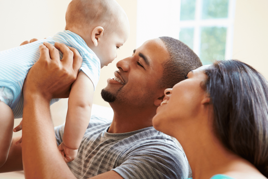 A growing family that consists of two happy parents and young baby 