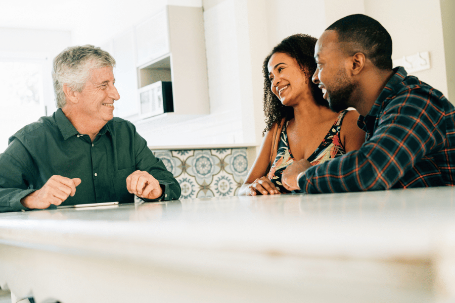 Couple sitting down at table to sign deed 