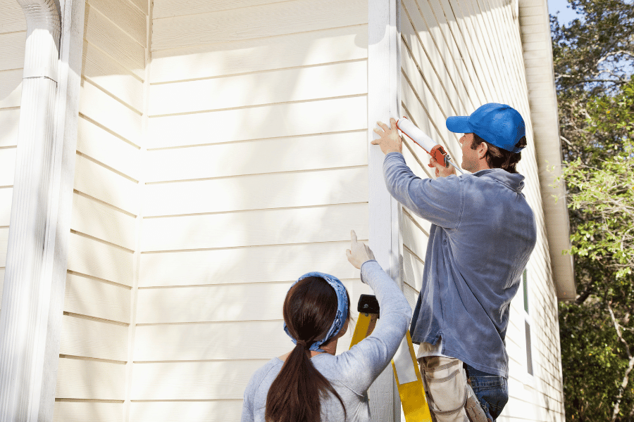 Home owners working on the outside of a home