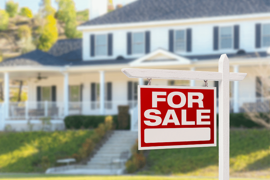 Beautiful white home with for sale sign in front of it