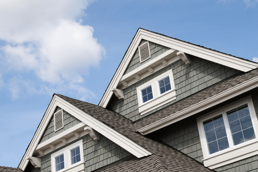 looking at the top of a gray house on a sunny day 