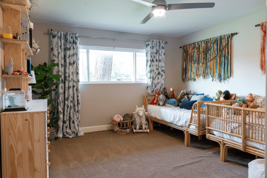 clean kids bedroom with stuffed animals on the beds 
