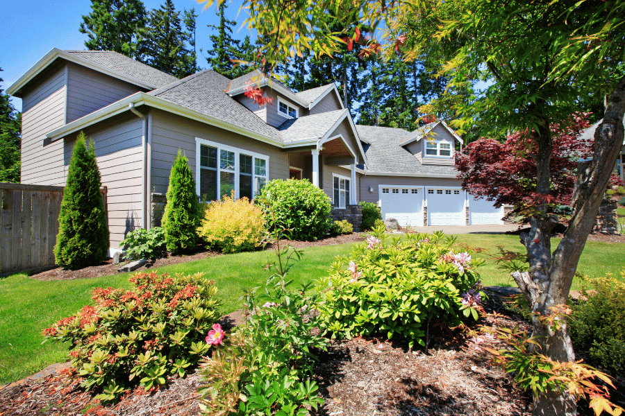 home for sale in the spring and summer with beautiful flowers out front