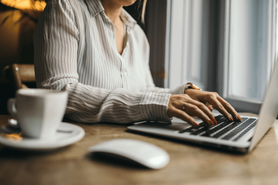 Assistant typing on the computer and wearing a striped shirt