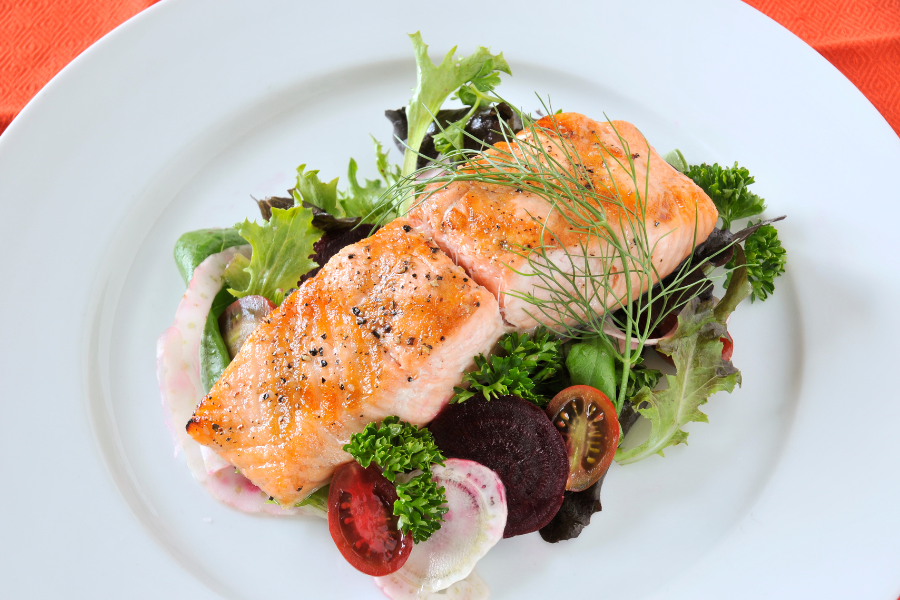 Salmon on a salad on a white plate