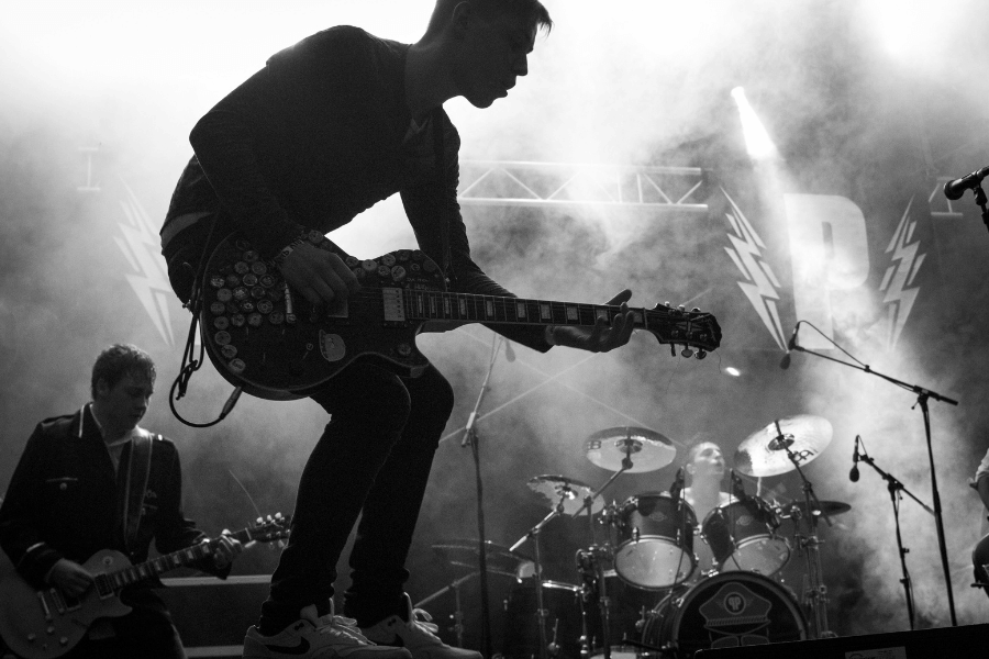 black and white photo of a guitarist and a band playing live music