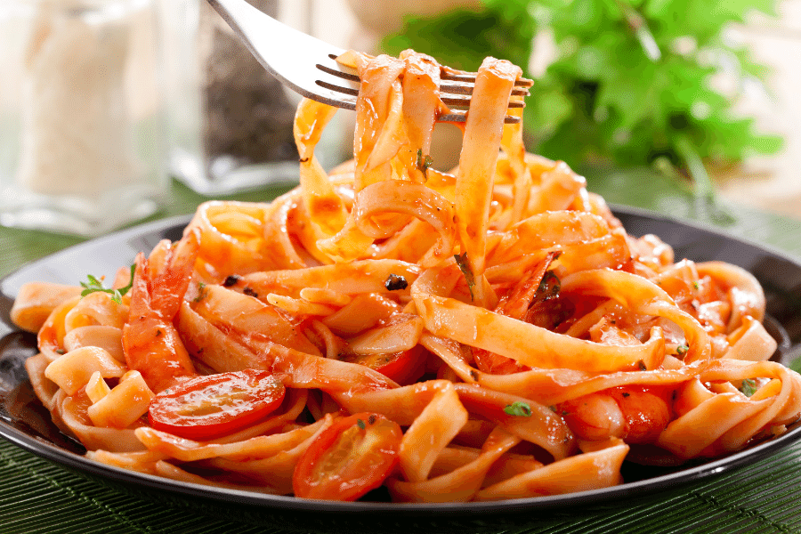 Eating pasta and tomatoes with a fork
