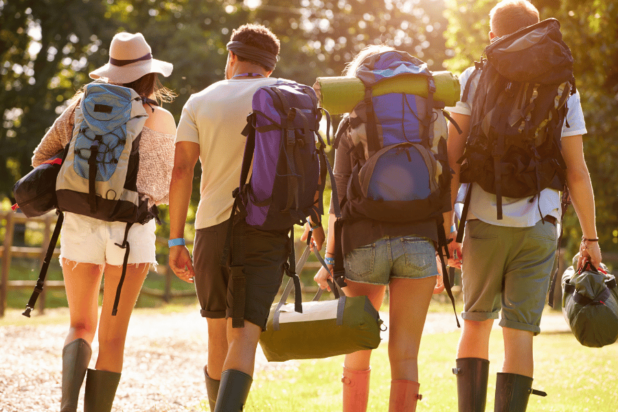 campers walking together with camping gear and backpacks