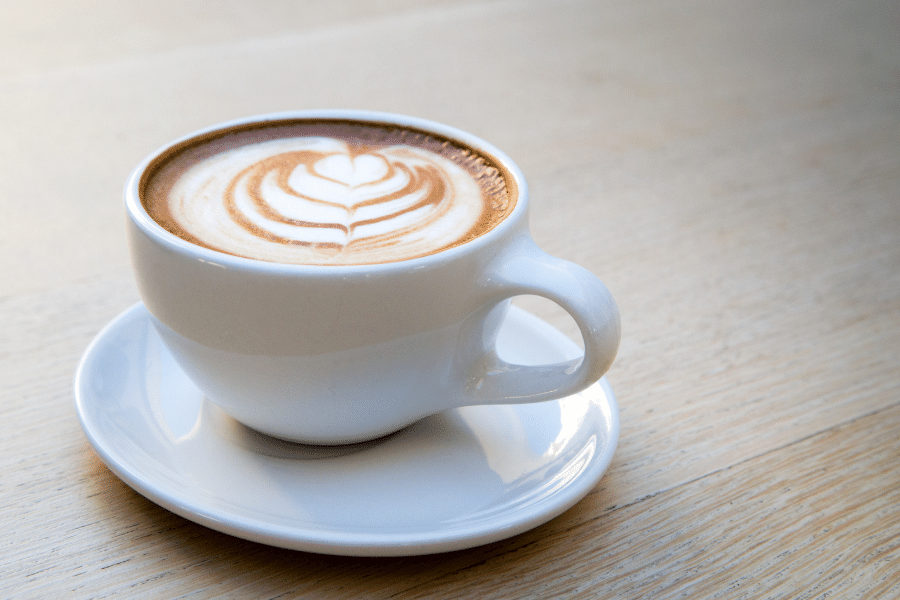 Latte in a white mug on wood table